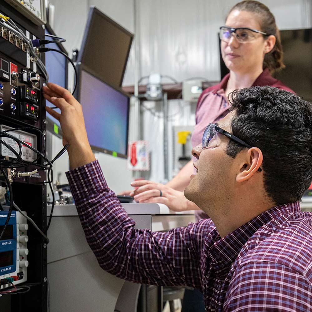 undergraduate students cooperate in a lab with electrical equipment