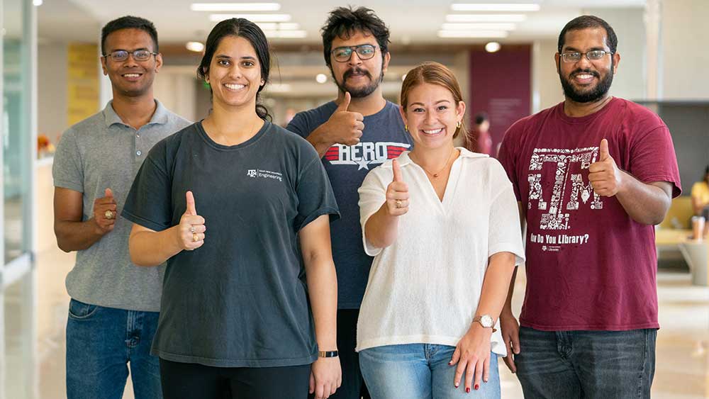 Group of people with thumbs up.