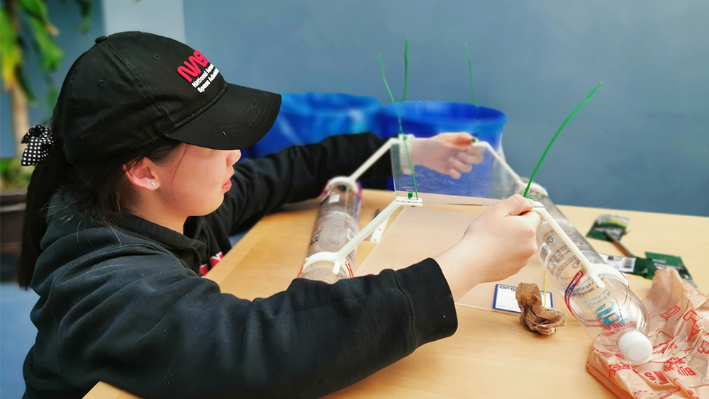 A female engineering student works on a prototype for a remote-controlled water vehicle