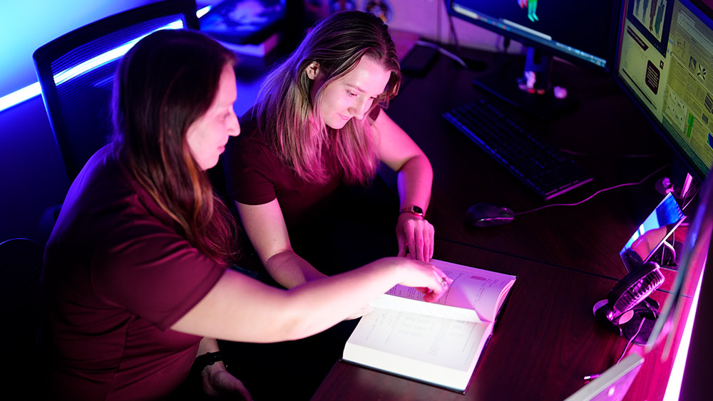 Two females looking at a book together