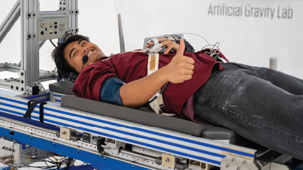aerospace engineering student laying down in the centrifuge for an experiment