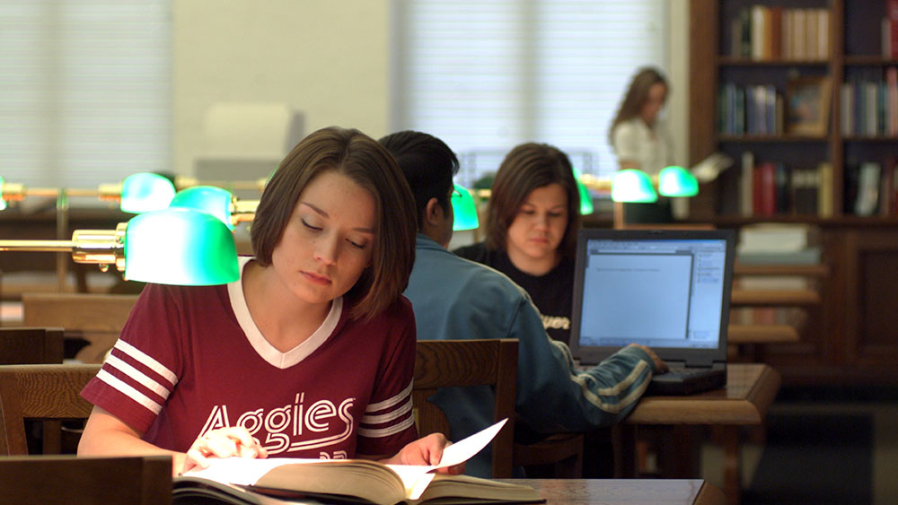 Student reading a book at library