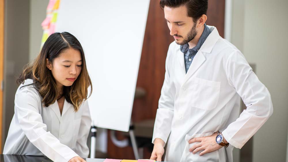 Two students discuss project plan in lab.