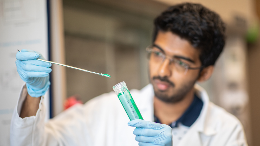 Student looks at gel substance in lab