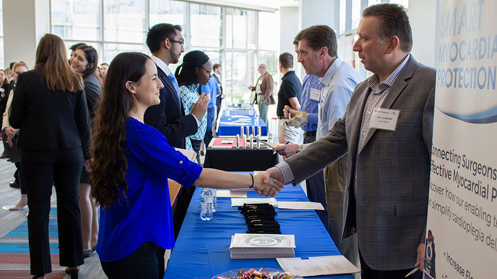 A recruiter and a student shake hands