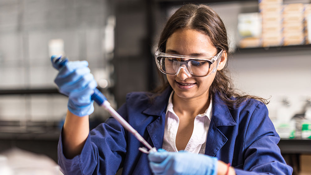 A student pipetting in a lab.