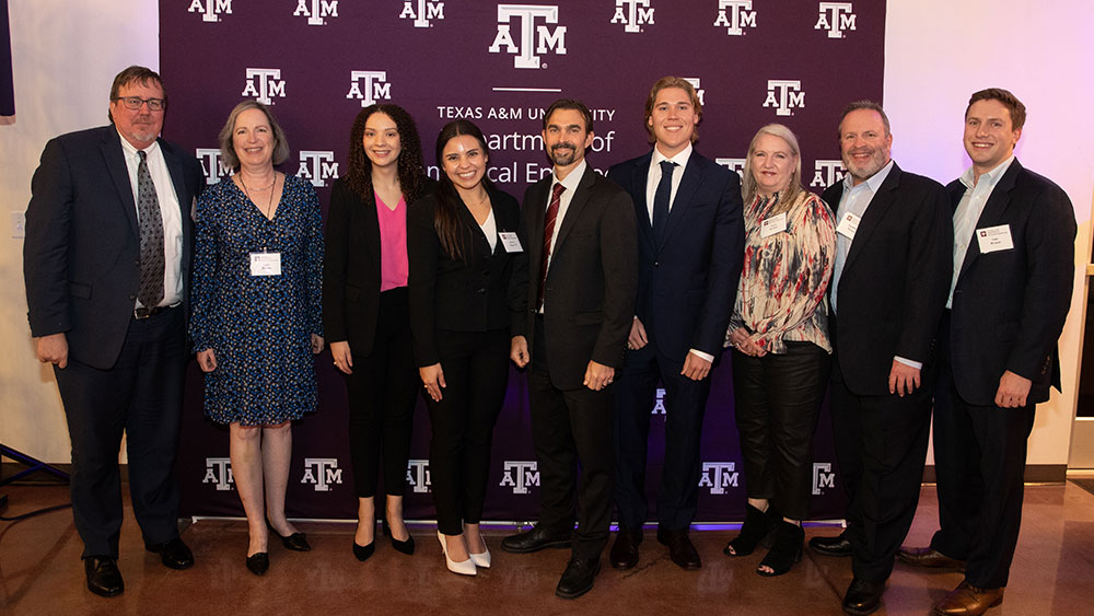 The Hymen family poses next to the student recipients of their scholarship