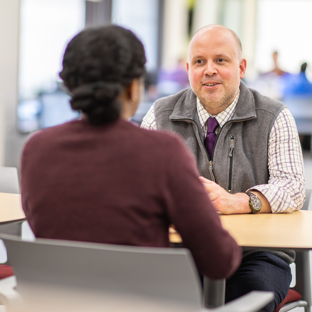 Student and graduate advisor at a table 