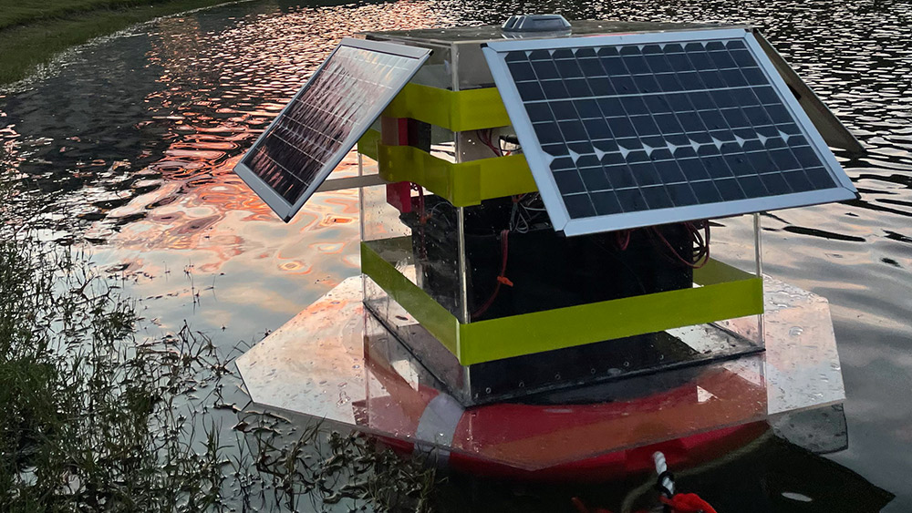 Intellifloat in the pond at Aggie Park under a setting sun behind Kyle Field.