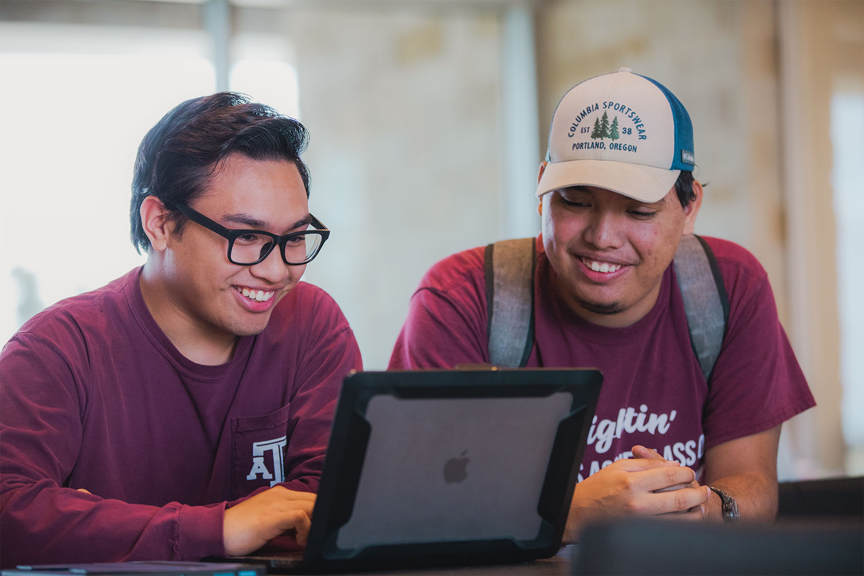 Students looking at a laptop. 