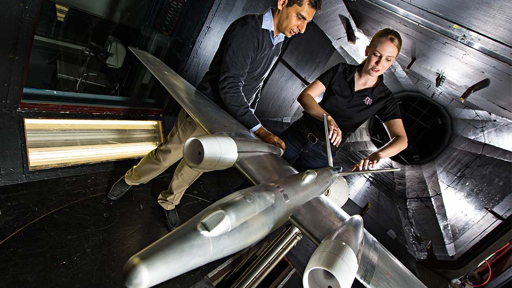 Students working on a model-sized jet plane.