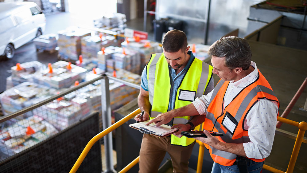 Team working with plans in a warehouse.