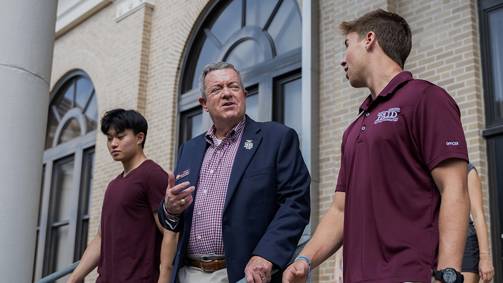 A professor talking with two students.
