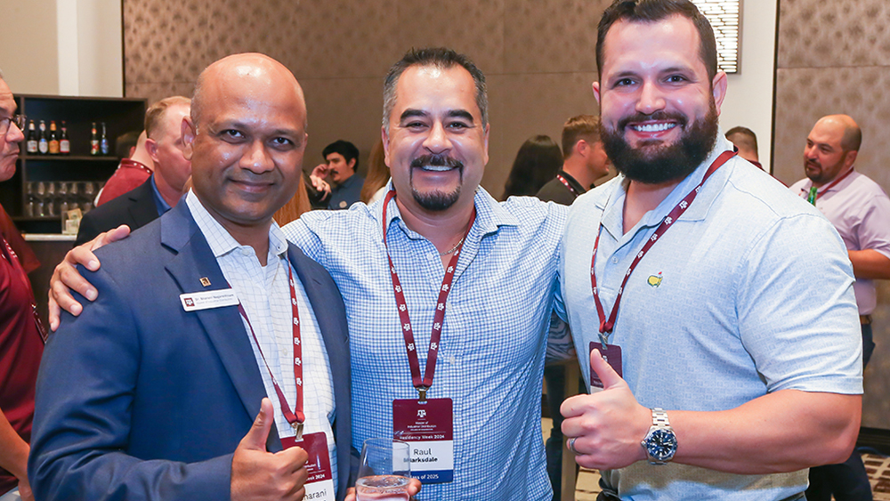 Three individuals smiling while giving thumbs up.