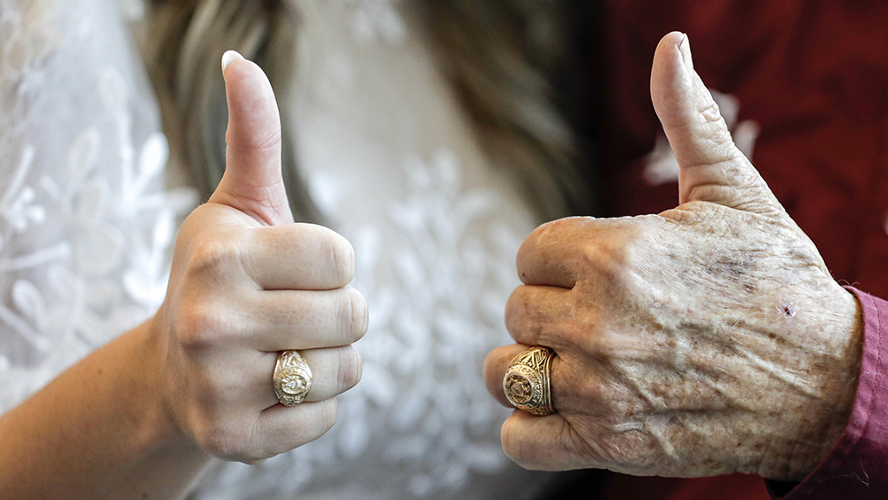 Close-up view of two hands, each wearing an Aggie ring and giving a thumbs-up gesture.