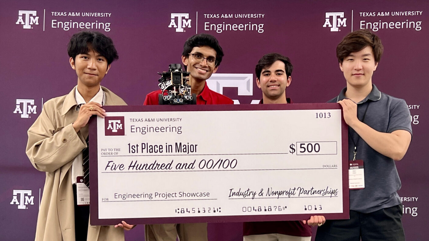 Four individuals pose with an oversize check while standing in front of a Texas A&amp;M College of Engineering branded maroon backdrop.