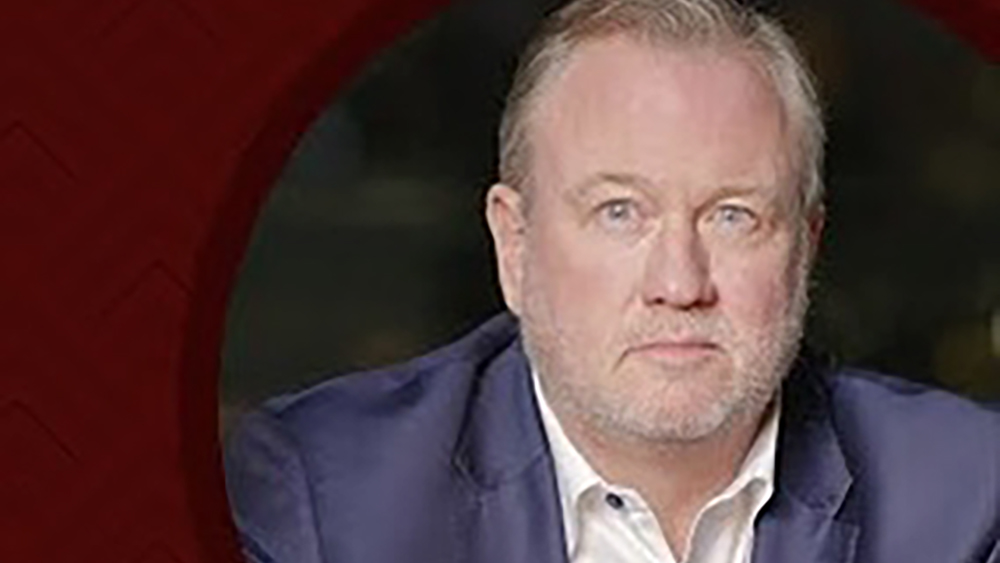 A man wearing a blue jacket and white shirt