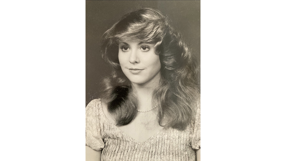 Black and white photo of a woman wearing a sweater and pearls