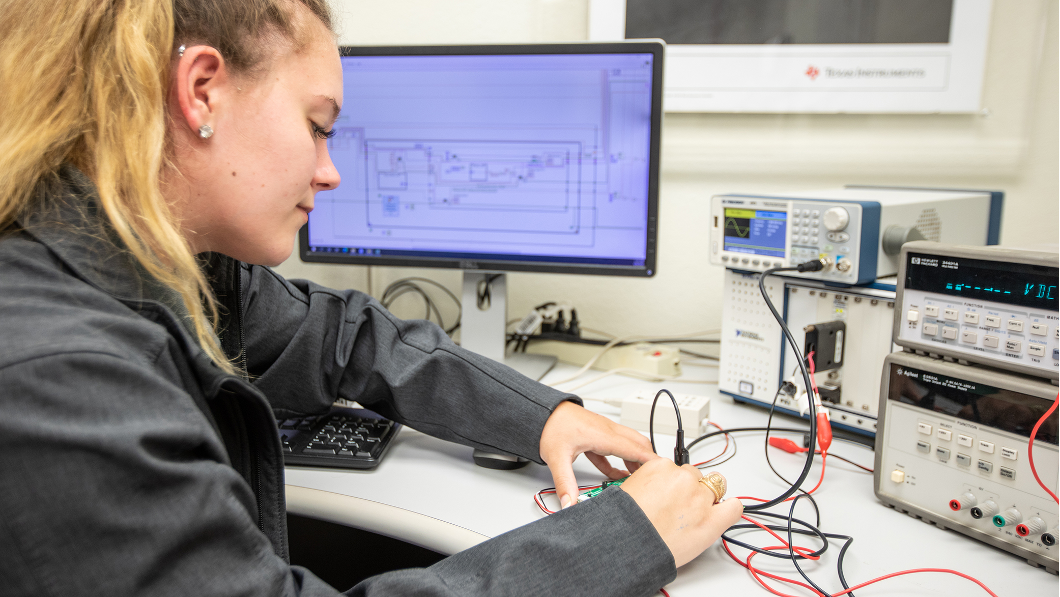 seated student attaching wires to a circuit board