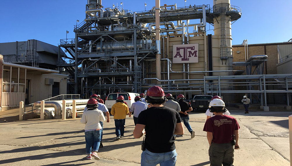 Students in hard hats walking outside of the Industrial Assessment Center