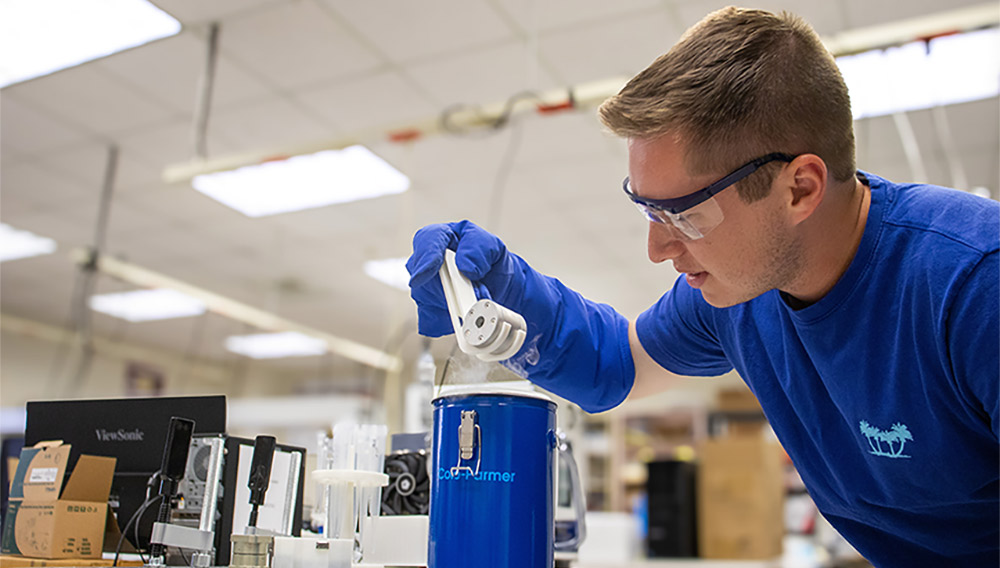 Male student in blue shirt working in lab