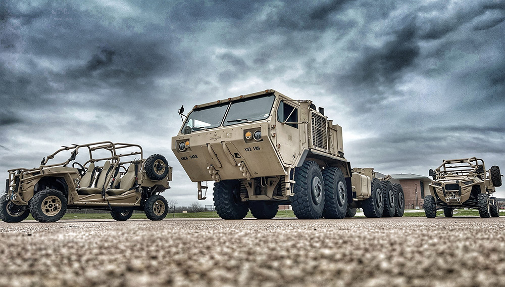 Three tan army vehicles parked on the tarmac at the RELLIS campus