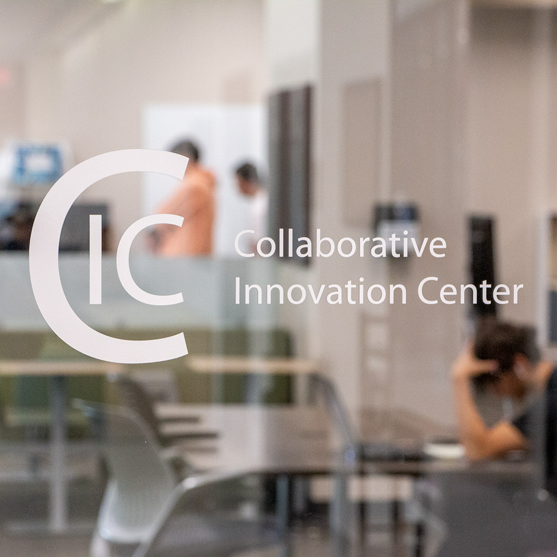 Glass door showing the text "CIC Collaborative Innovation Center" with students in the room behind it.