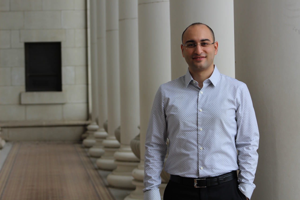 Saghati standing in walkway of building between two rows of columns.