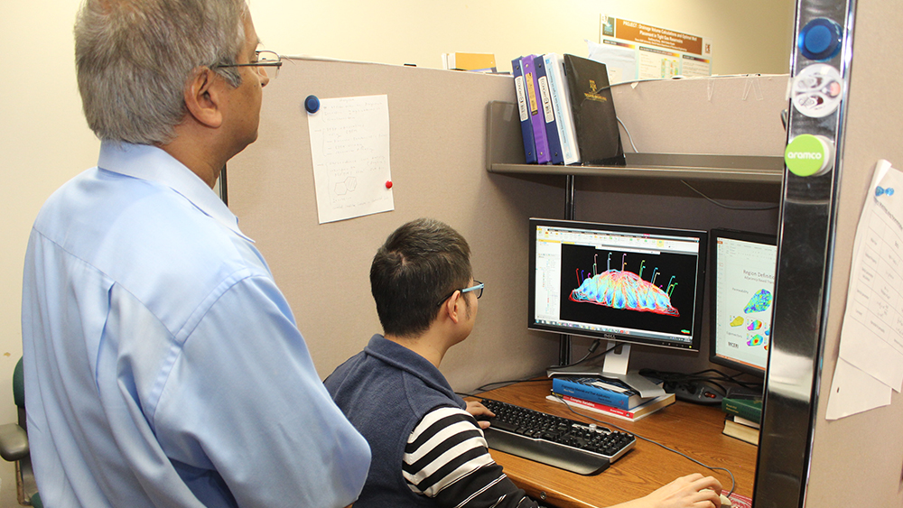 Akhil Datta-Gupta and one of his students in front of a streamline computer image