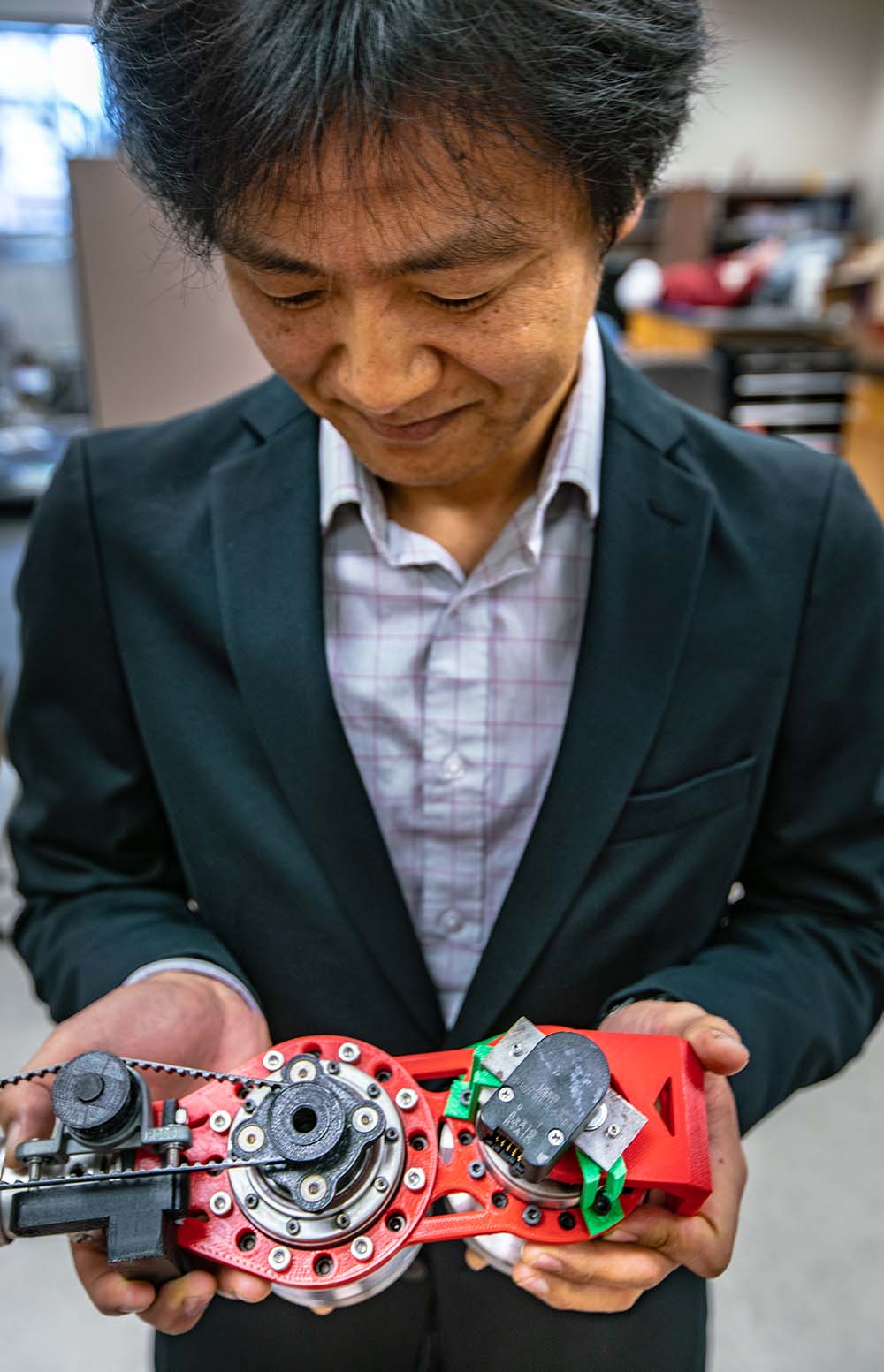 Man looking down at prothetic device in his hands.