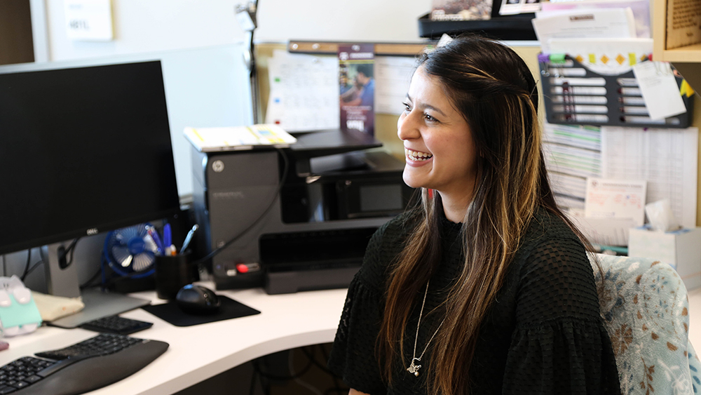 Analicia Leiva sits in her  cubicle