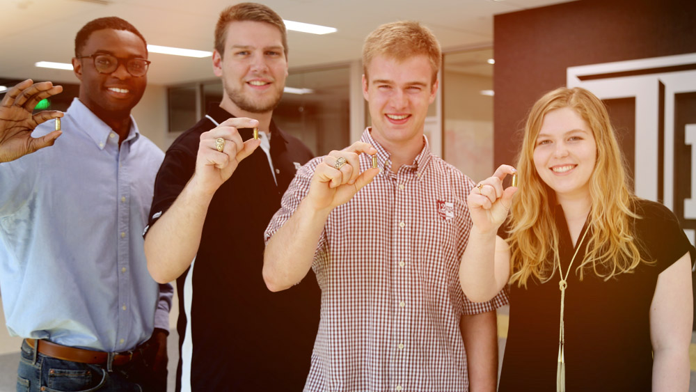 Team members hold Lazarus bullets in the ZACH building.