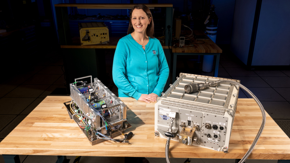 Hermes Principal Investigator, Dr. Kristen John, stands in front of the Hermes hardware.