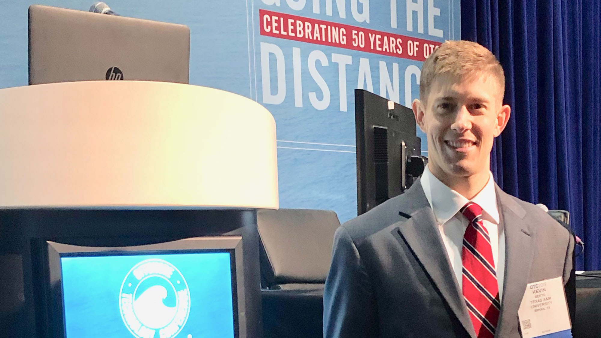 Berto stands in front of the stage at the 2019 SNAME conference.