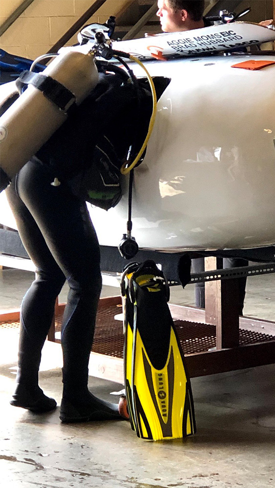 A submarine team member makes adjustments inside the submarine.