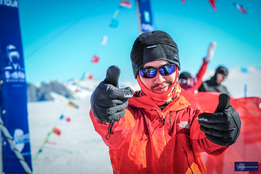 Kentaro Iio dressed in winter gear gives a Gig 'em (thumbs up) before the race begins. 