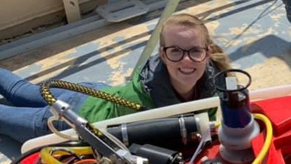 Ocean engineering senior Lucy Miller beside the Human Powered Submarine