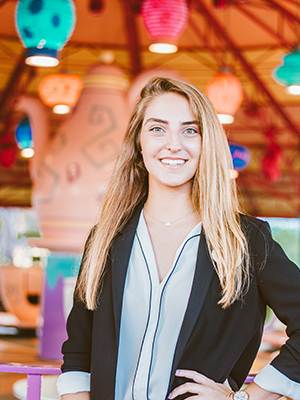 Stephanie Cruz stands in front of a ride in Walt Disney World. 