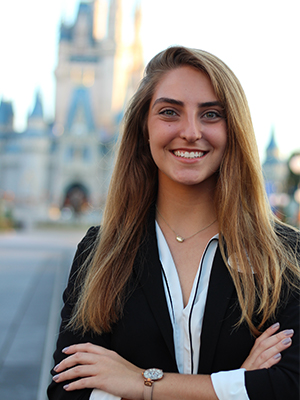 Stephanie Cruz stands in front of Cinderella's castle at Walt Disney World resort. 