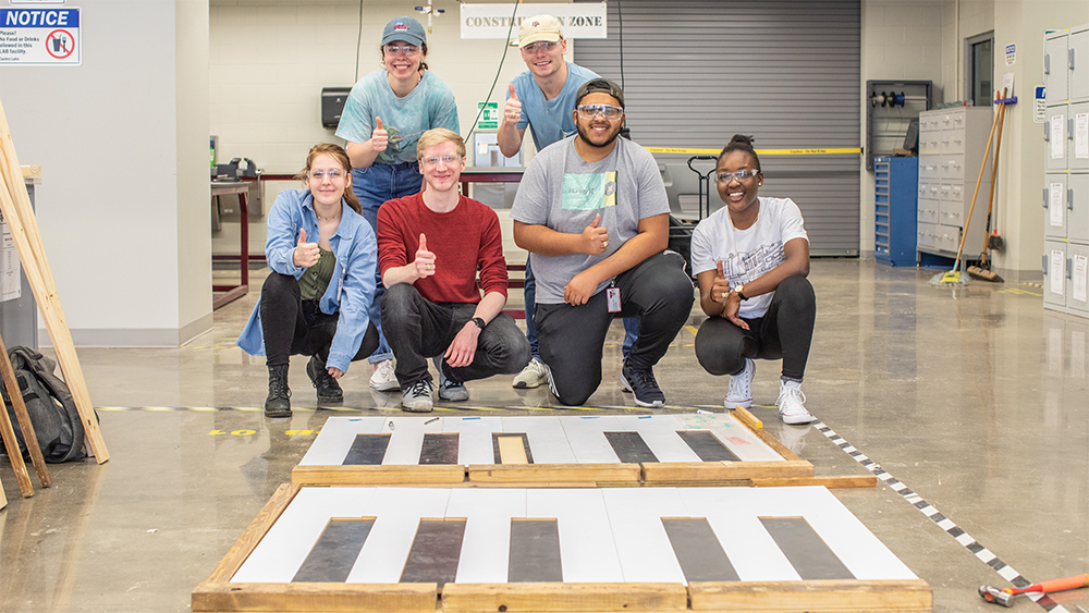 Mechanical Engineering Capstone group with their project, walk-on piano