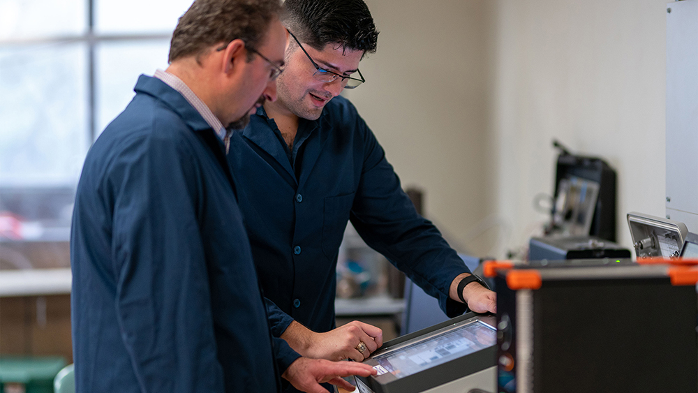 Enrique Losoya and Dr. Eduardo Gildin reviewing computer and software set up for simulations in petroleum engineering lab in Richardson Building on Texas A&amp;M University campus