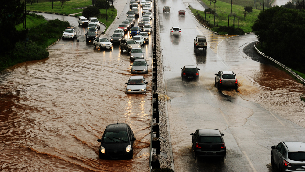 Cars drive through flooded streets