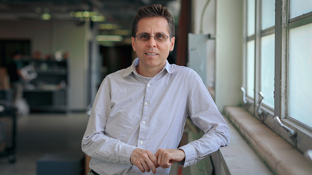 Dr. Homero Castaneda stands in the lab near a window