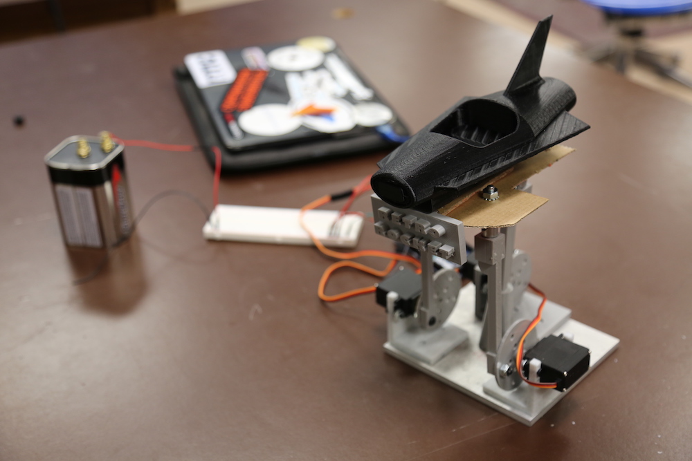 Small scale model of a black rocket car from a 1950s carnival ride.