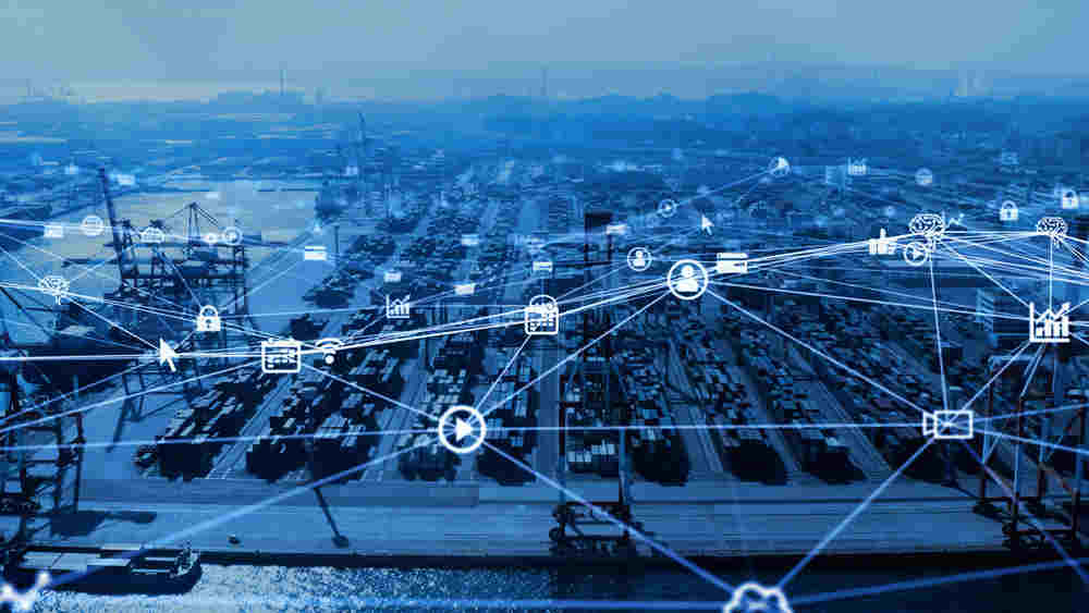 A network of business related icons transposed over a cargo shipyard