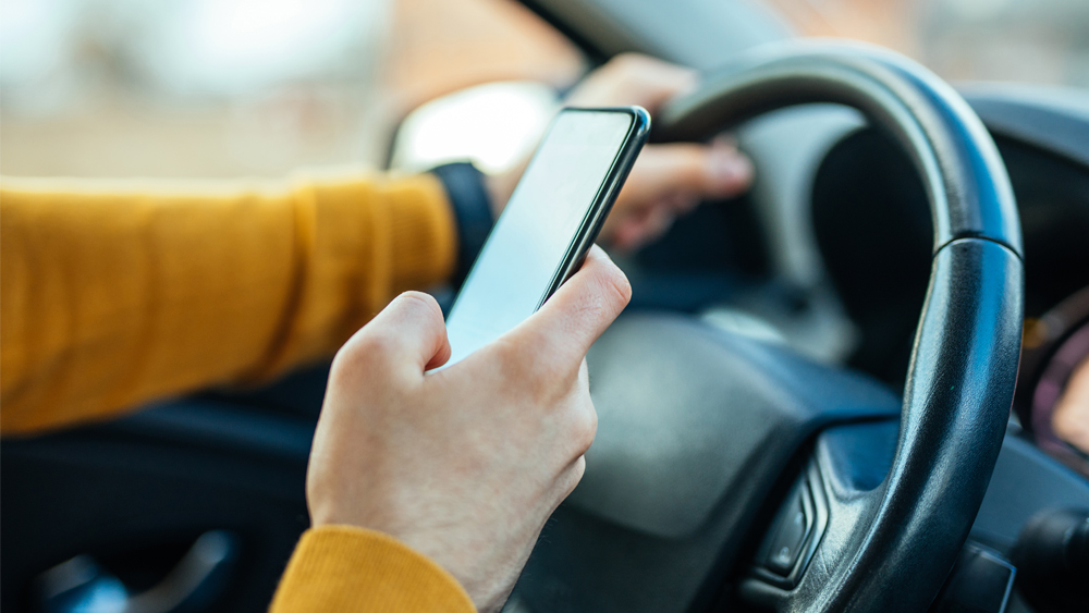 A person holding a cell phone while driving a vehicle 