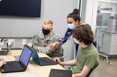 Three students discuss project in study room