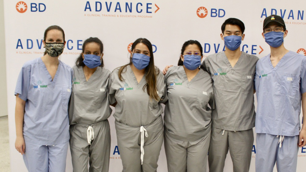 Students in mask stand next to their sponsor from BD.