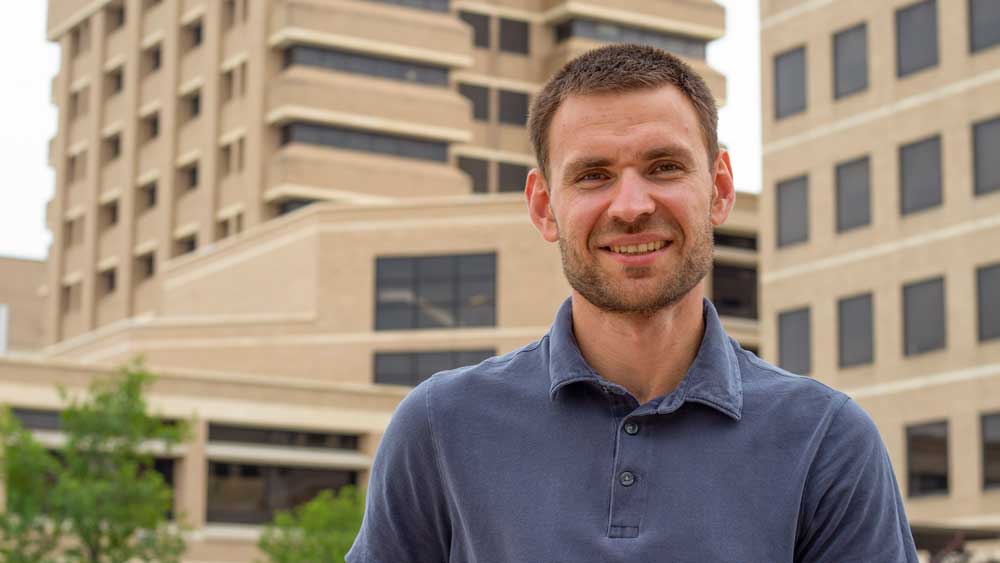 Dr. Igor Ivanishin smiling and seated outdoors on the Texas A&M University campus