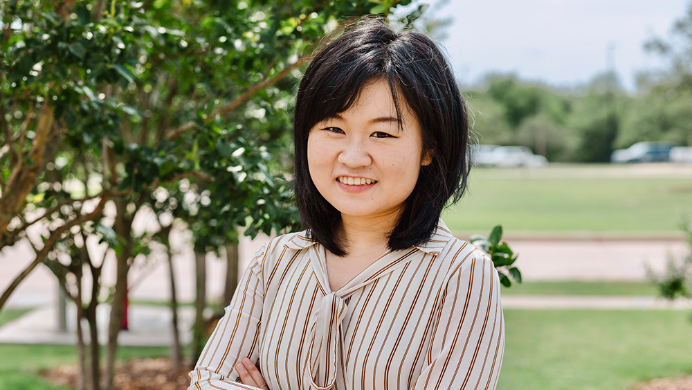 Mengying Liu stands outdoors and smiles.